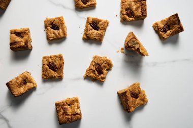 Beyaz mermer tezgahta sarı kurabiyelerin üst görüntüsü. Beyaz çikolata tatlı ve lezzetli, çiğnenmiş kurabiyeler. Yüksek kalite fotoğraf