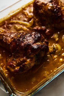 Hindi kanatlarını dikdörtgen pişirme kalıbında boğmuş. Yemek fotoğrafı. Kıtır kıtır kızartılmış, kanatları kalın bir sosun içinde sebzelerle boğulmuş. - Evet. Yüksek kalite fotoğraf