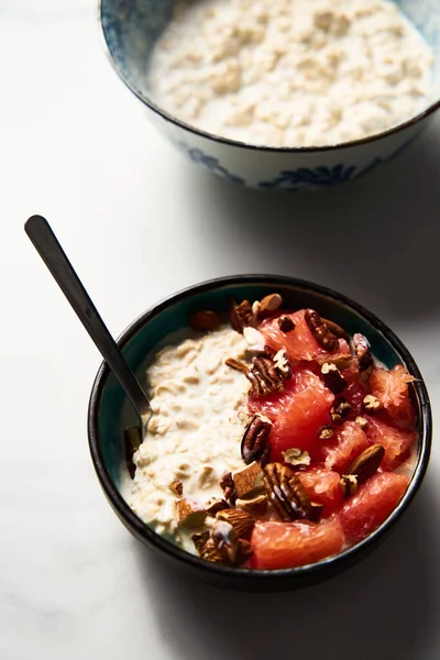 Overnight oats with milk and greek yogurt ingredients list. healthy breakfast with nuts with grapefruit, honey and cinnamon. High quality photo
