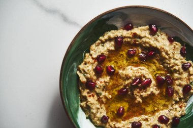 Baba ganoush. Kızarmış patlıcandan yapılmış dumanlı bir Orta Doğu sosu tahini ile harmanlanmış limon suyu sarımsak ve zeytinyağıyla karıştırılmış. Genellikle maydanozla süslenir ve pide ile servis edilir. Yüksek kalite