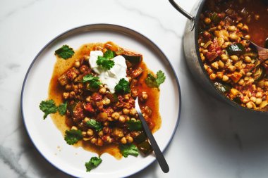 Nohut Tagine. aromatik baharatlar, domatesler ve soğanlar içinde kaynatılmış taze bezelyeli lezzetli Fas güveci. Genellikle otlarla süslenir ve kuskus veya ekmekle servis edilir. Yüksek kalite fotoğraf