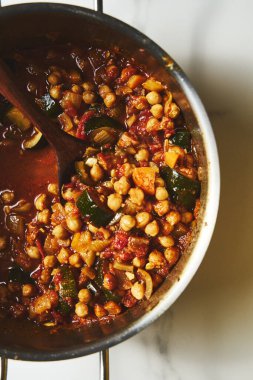 Nohut Tagine. aromatik baharatlar, domatesler ve soğanlar içinde kaynatılmış taze bezelyeli lezzetli Fas güveci. Genellikle otlarla süslenir ve kuskus veya ekmekle servis edilir. Yüksek kalite fotoğraf