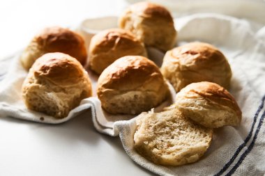 Burger Buns ya da tel askıda mini çörekler. Çok yumuşak, taze ev yapımı, tereyağlı. Beyaz mermer arka plan. Minimalist fotoğraf. Yüksek kalite fotoğraf