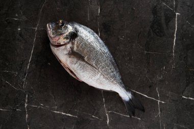 Kır tavasında iki çiğ ve taze dorado balığı. Minimalist, koyu renkli ya da sade yemek fotoğrafı. Akdeniz diyeti. Yüksek kalite fotoğraf