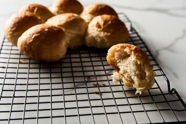 Burger Buns ya da tel askıda mini çörekler. Çok yumuşak, taze ev yapımı, tereyağlı. Beyaz mermer arka plan. Minimalist fotoğraf. Yüksek kalite fotoğraf