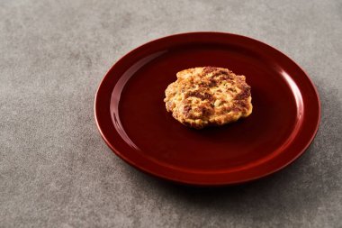 Beton arka planda beyaz tabakta mozzarella peynirli tek Altın Kahverengi Tavuk Pirzolası. Yüksek kalite fotoğraf