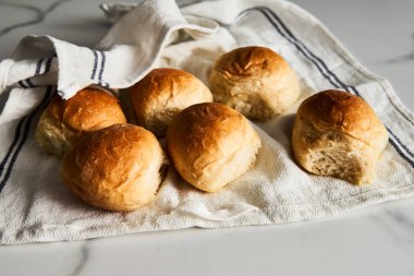 Burger Buns ya da tel askıda mini çörekler. Çok yumuşak, taze ev yapımı, tereyağlı. Beyaz mermer arka plan. Minimalist fotoğraf. Yüksek kalite fotoğraf