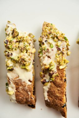 Beyaz mermer kaplama tavada beyaz tabakta Altın Biscotti veya Cantuccini. Geleneksel tatlı İtalyan kurabiyeleri iki kez pişirilmiş, fındıklı ve kuru yaban mersinli.