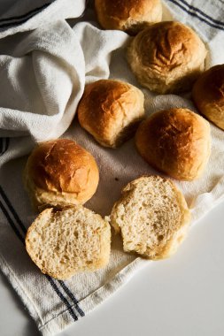 Burger Buns ya da tel askıda mini çörekler. Çok yumuşak, taze ev yapımı, tereyağlı. Beyaz mermer arka plan. Minimalist fotoğraf. Yüksek kalite fotoğraf