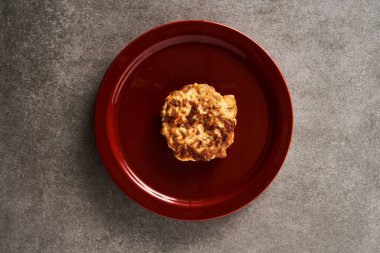 Beton zeminde kırmızı tabakta mozzarella peynirli tek Altın Kahverengi Tavuk Pirzolası. Üst Görünüm Yüksek Kalite Fotoğraf