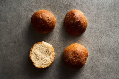 Gri beton arka planda hamburger ekmeği ya da mini çörekler. Çok yumuşak, taze ev yapımı, tereyağlı. Minimalist fotoğraf. Üst Manzara. Yüksek kalite fotoğraf