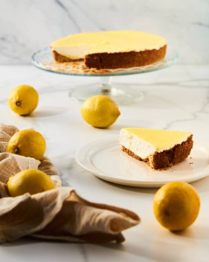 Limonlu peynirli kek ve kurabiye tabanı var. Beyaz mermer arka plan. Yüksek anahtarlı yemek fotoğrafı Yüksek kaliteli fotoğraf