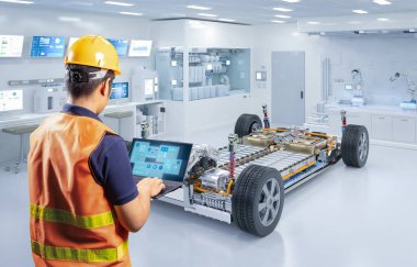 Asyalı mühendis veya teknisyen laboratuarda her arabanın akü modülüyle çalışıyor.