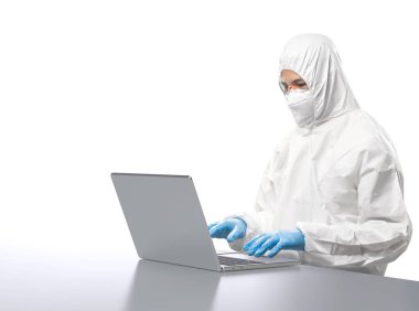 Worker wears medical protective suit or white coverall suit work with computer notebook isolated on white background