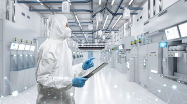 Worker or engineer wears protective suit or white coverall suit work in semiconductor manufacturing factory