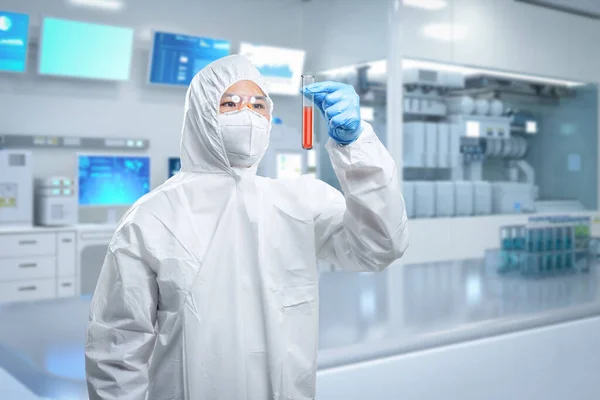Worker wears medical protective suit or white coverall suit with test tube in laboratory