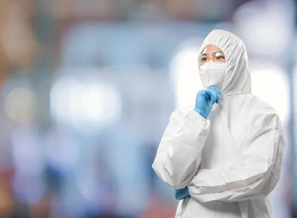 Worker wears medical protective suit or white coverall suit with mask and goggles