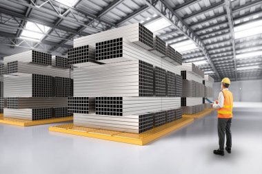 Asyalı mühendis veya teknisyen, dikdörtgen borularla çelik fabrikasında çalışıyor.