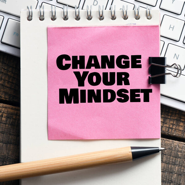 Change Your Mindset text notepad and on office wooden table