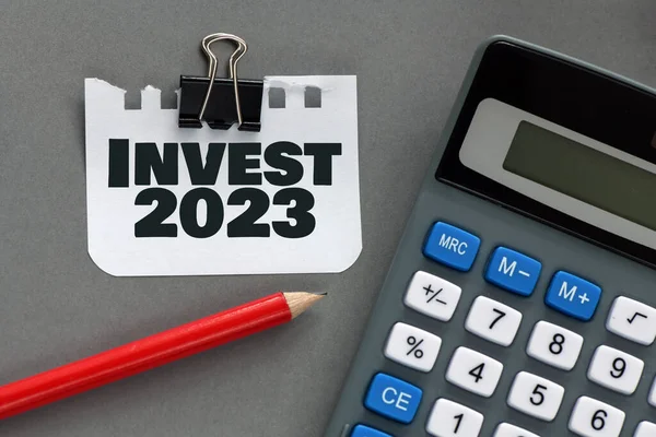 Invest 2023 Słowa Małym Kawałku Papieru Obok Kalkulatora — Zdjęcie stockowe