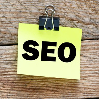 Küçük sarı bir kağıt ve ahşap bir masa üzerinde 