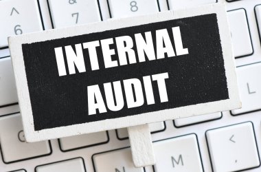 Bir bilgisayar klavyesinde bulunan küçük bir karatahtadaki INTERNAL AUDIT sözcükleri.