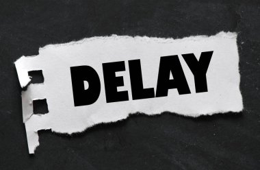 DELAY words on a small sheet of paper on a black background. A concept for business.  clipart