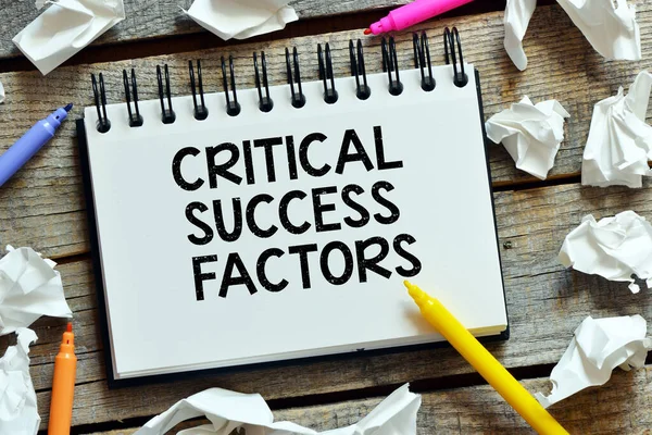 CRITICAL SUCCESS FACTORS words in an office notebook.