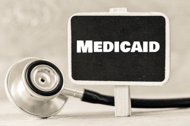 Medicaid kelimesi tebeşir tahtasında steteskopun yanında..