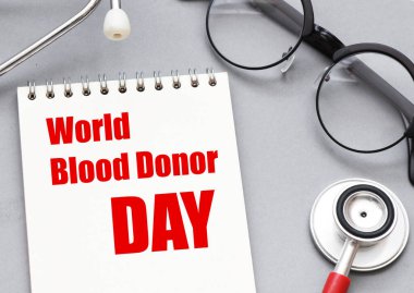 Ofis defterinde steteskopun yanında dünya kan bağışı günü kelimeleri..