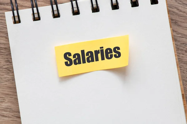 Salarissen Concept Het Woord Salaries Een Klein Velletje Een Kantoorboekje — Stockfoto