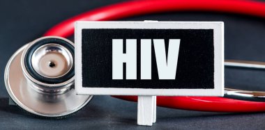 Steteskopun yanında küçük bir tebeşir tahtasında HIV kelimesi.
