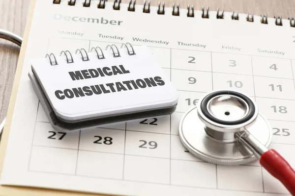 Arztkonsultation Büroheft Auf Einem Kalender Neben Einem Stethoskop — Stockfoto