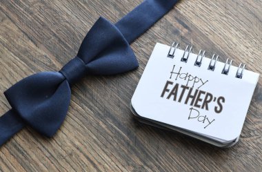 Not defterinde ve tahta zeminde Babalar Günü mesajın kutlu olsun. Selamlar ve hediyeler.