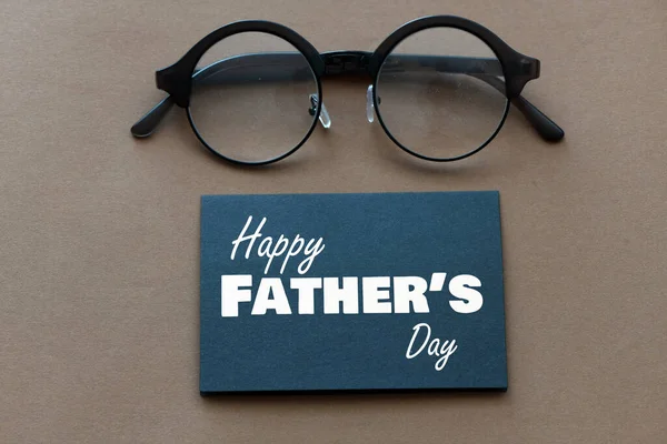木製の背景に黒い紙の上の幸せな父の日のテキスト 挨拶とプレゼント — ストック写真