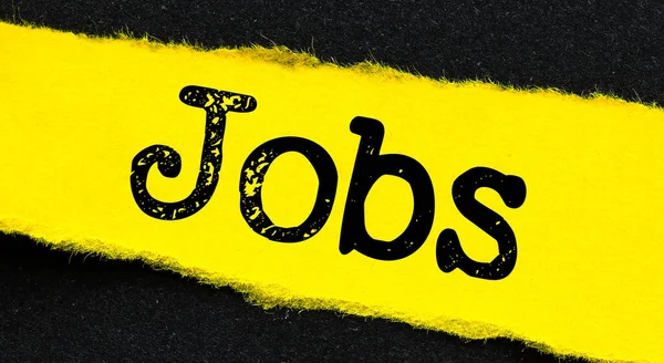 Słowo Jobs Małym Żółtym Kawałku Papieru Czarnym Tle — Zdjęcie stockowe