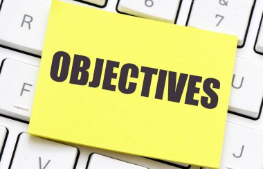 Bir parça kağıt ve klavyede OBJECTIVES sözcüğü