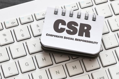 Ofis defterindeki kurumsal sosyal sorumluluk (CSR) kelimeleri. Yukarıdan görünüm.