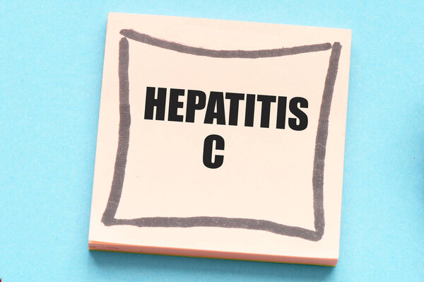 Concept of HEPATITIS C words in an office notebook next to a stethoscope and a heart.