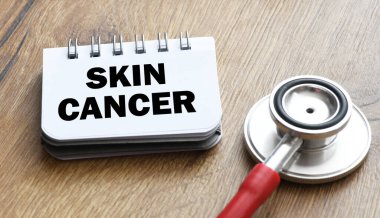 Steteskopun yanındaki küçük bir ofis defterinde SKIN CANCER kelimesi.