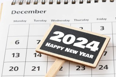 Yeni yılınız kutlu olsun. Küçük bir tebeşir tahtası ve takvimde 2024 kelime..