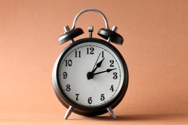 Kahverengi arkaplanda siyah alarm saati.