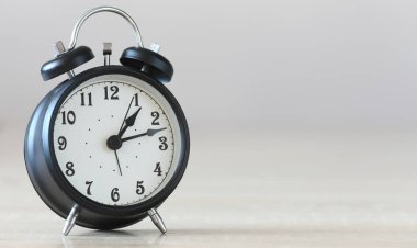 Gri arkaplanda siyah alarm saati.