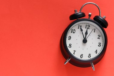 Kırmızı arkaplanda siyah alarm saati.