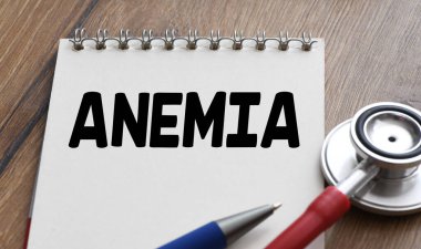 Bir steteskopun yanındaki defterde ANEMIA kelimesi.