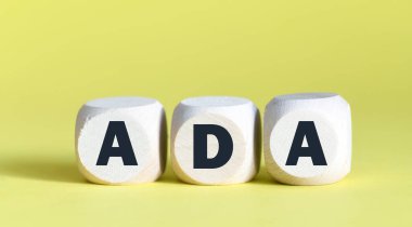 Tahta bloklar ve sarı arka plan hakkında ADA sözcüğü.