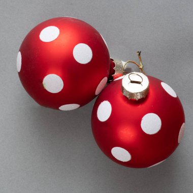Gri arkaplanda beyaz noktalar olan kırmızı Noel ağacı kabarcıkları.
