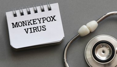 MonkeyPOX VIRUS 'un gri arka planda steteskop ile yazılmış kelimeleri. Maymun Çiçeği virüsü olarak da bilinir..