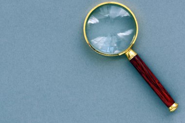 Gri arkaplanda eski büyüteç.