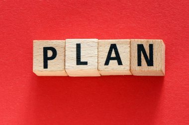 Plan kelimesi kırmızı arkaplandaki ahşap harflerden düzenlenmiş.